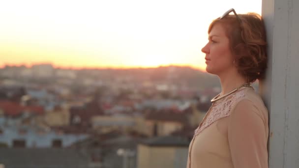 Sad young woman dreamily looks away on the city bridge. Urban cityscape background — Stock Video