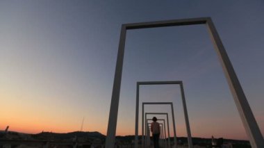 Sunset bulvarında yüksek teknolojili şehir köprüsü üzerinde yürüyen güzel genç kentsel moda kadın. Arkadan Görünüm