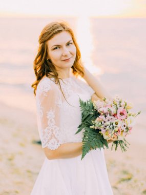 Gelin buketi tutarak yakın çekim portre. Gün batımı kompozisyon.