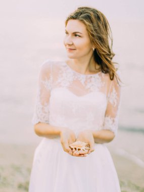 Gelin sağ tarafta deniz arka plan, kabuk tutarken arıyor.