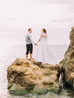 Elele ve dağlarda aşağı zaman harcama yeni evliler dikey arkadan görünüm.