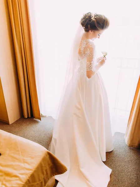 Pemandangan belakang mempelai wanita cantik dengan gaun putih panjang memegang buket mini . — Stok Foto
