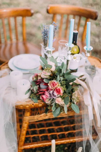 Vista de close-up do lindo conjunto de mesa de casamento decorado. O buquê de casamento na mesa tecida . — Fotografia de Stock