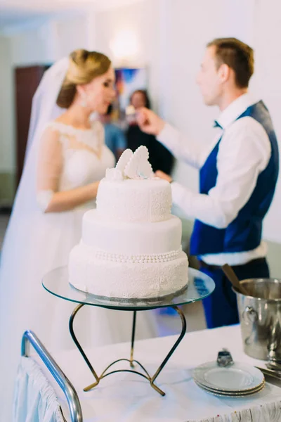 Close-up photo biały tort weselny z kwiatami w niewyraźne tło dla nowożeńców. — Zdjęcie stockowe