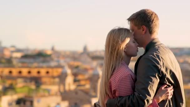 Portret de jeunes couples magnifiques embrasser et embrasser contre le panorama de Rome au coucher du soleil. Date romantique de l'homme et de la femme heureux. Vidéo 4K . — Video