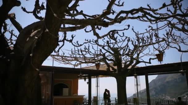 Video de una joven hermosa pareja abrazándose y besándose en la terraza. En el fondo montañas italianas. Increíble vista y ambiente perfecto. Vídeo 4K . — Vídeo de stock