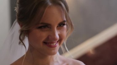 Kapatın. Muhteşem bir gelinlik ve duvak takmış güzel bir gelin, damadın karşısında tatlı tatlı gülümsüyor ve gelin mutluluktan ağlıyor. Düğün töreni, mutlu anlar, çift golü..