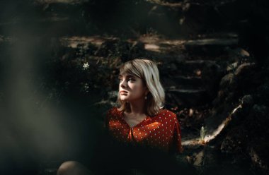 Oturan güzel bir kadın doğanın tadını çıkarıyor, güzel bir kız dışarıda dinleniyor. Yakın plan.