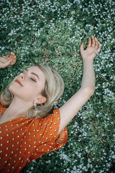 Hermosa mujer acostada disfrutando del campo de margaritas, chica bonita relajándose al aire libre. Primer plano Fotos De Stock