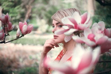 Sakura dallarının arasında duran güzel bir kadın, dışarıda dinlenen güzel bir kız. Yumuşak pembe renkler