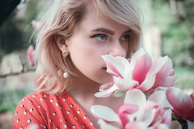 Sakura dallarının arasında duran güzel bir kadın, dışarıda dinlenen güzel bir kız. Yumuşak pembe renkler. C