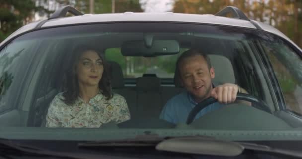 Щаслива пара балакає і їде по дорозі в машині — стокове відео