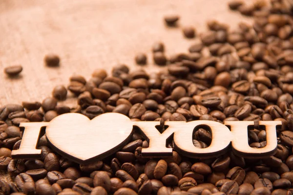 Les mots "je t'aime" et les grains de café. Gros plan — Photo