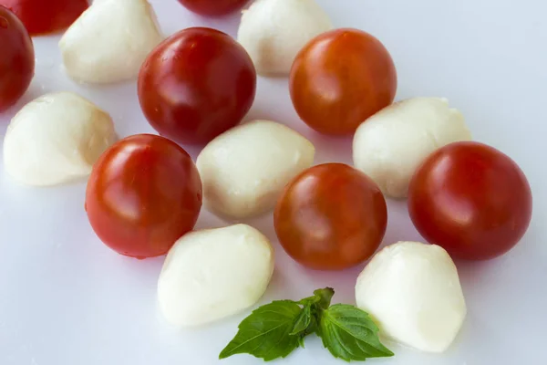 Mozzarella-Bällchen und Tomaten auf weißem Hintergrund — Stockfoto