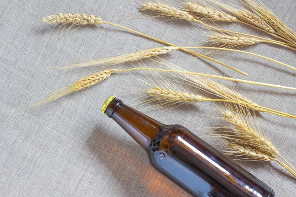 Flasche Bier und Weizen auf Säcken — Stockfoto