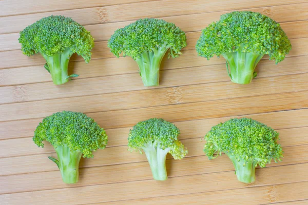 Kepala brokoli kecil dengan latar belakang kayu. tampilan atas — Stok Foto