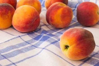 Mavi ve beyaz masa örtüsü üzerinde şeftali