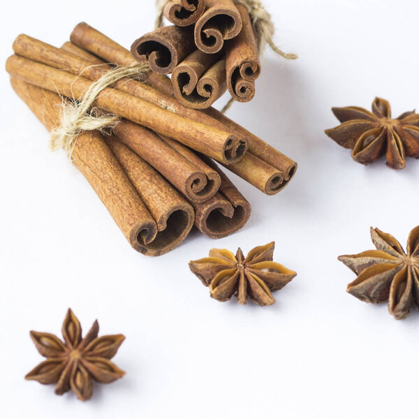 Spices: star anise and cinnamon sticks on white background.