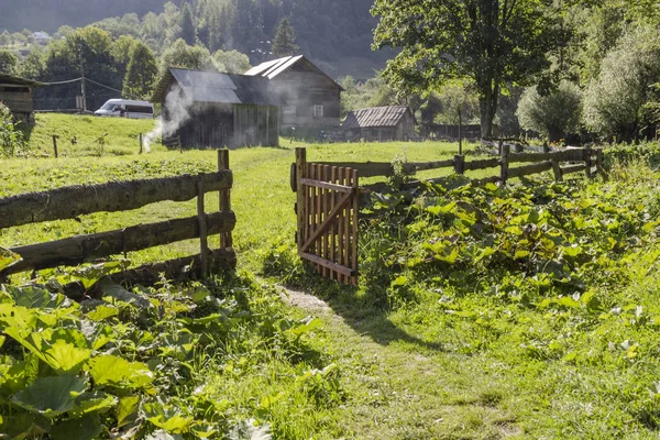 Village landscape, houses, fence and open gate