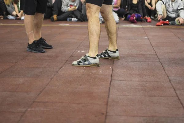 Sports background. Athletes legs in sneakers. Fans behind the yellow line