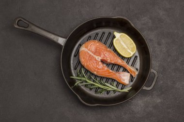 Siyah arka planda somon, limon ve biberiye. 