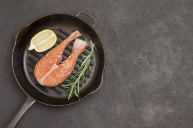 Siyah arka planda somon, limon ve biberiye. Omega 3 'ün besin kaynakları. Sağlıklı besin. 