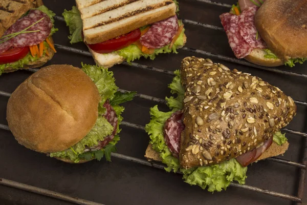Σάντουιτς με κρέας και χόρτα, κουλούρι με κόκκους σε μεταλλική σχάρα. — Φωτογραφία Αρχείου