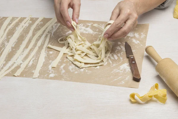 Process of making cooking homemade pasta.  Rolled dough, sliced into strips — 스톡 사진