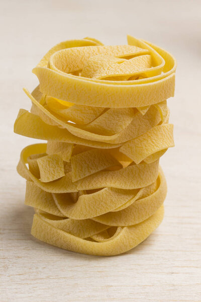 Raw wheat pasta on white background