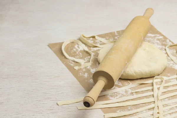 Rolling pin and dough cut into strips — 스톡 사진