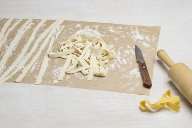 Hamur şeritleri şeklinde kesilmiş. Ev yapımı erişte yapma süreci.