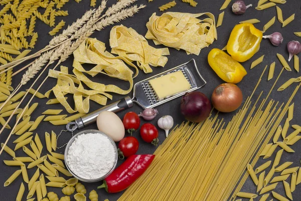 Organic food  on black background. Variety of types and shapes of Italian pasta