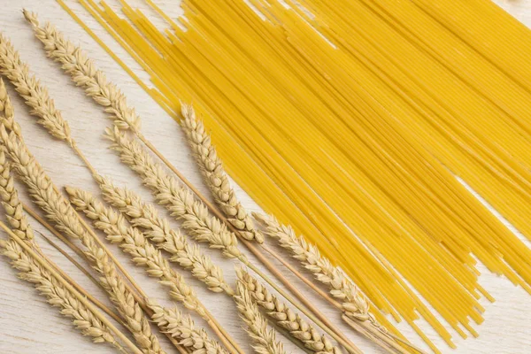 Alimentos orgânicos, várias massas não cozidas e espiguetas de trigo em branco — Fotografia de Stock