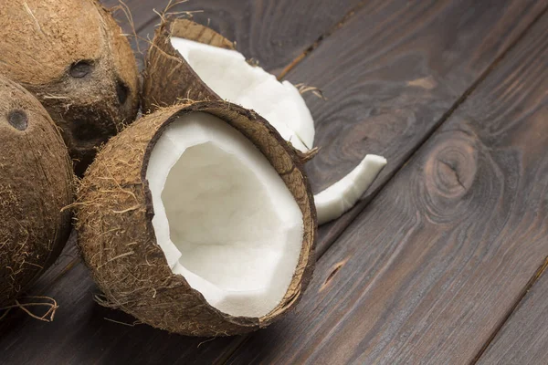 Coco, cortado em meio coco sobre fundo de madeira escura — Fotografia de Stock