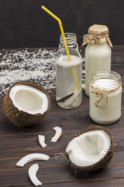 Hindistan cevizi içeceği, hindistan cevizi ve hindistan cevizi gevreği. Hindistan cevizi ve hindistan cevizi gevreği. Sebzeli vejetaryen yemeği. Sağlıklı beslenme konsepti. Koyu ahşap arka plan. Dikey