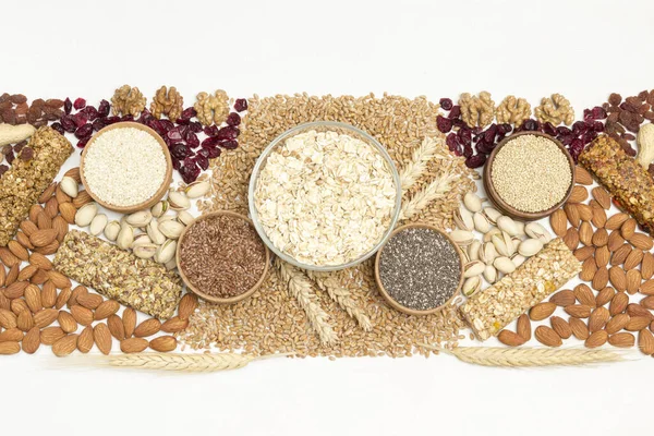 Dengeli protein granola barı. Tahta arka planda fındık, tohum, tahıl. Sağlıklı diyet vejetaryen yemekleri. Düz yatıyordu. Beyaz arka plan. Boşluğu kopyala