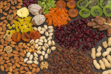 Besleyici Enerji Atıştırması. Şekerli meyve, kuru meyve fındığı. Sağlıklı vejetaryen yemekleri. Siyah arka plan. Düz yatıyordu