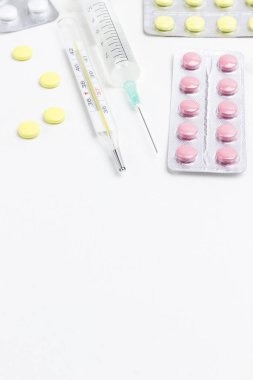 Soğuk algınlığı ve termometreyi tedavi etmek için hap, beyaz şırınga. Tıbbi kavramlar ve ilaçlar. Uzayı kopyala Üst görünüm