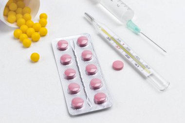 Soğuk algınlığı ve termometreyi tedavi etmek için hap, beyaz şırınga. Tıbbi kavramlar ve ilaçlar. Uzayı kopyala Üst görünüm