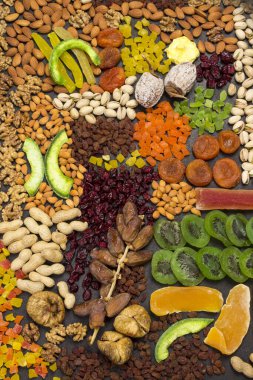 Besleyici Enerji Atıştırması. Şekerli meyve, kuru meyve fındığı. Sağlıklı vejetaryen yemekleri. Siyah arka plan. Düz yatıyordu