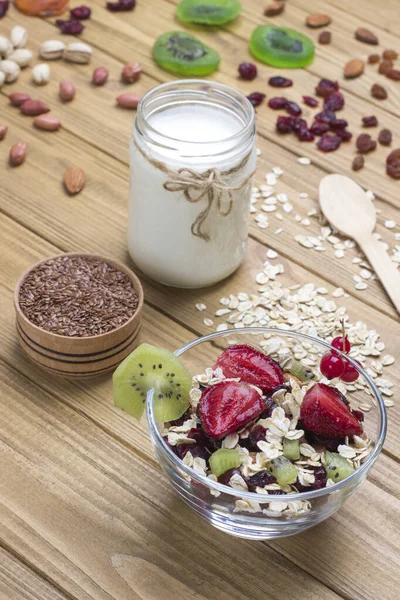 Muesli balanced protein breakfast. Fruits, berries seeds, nuts. Coconut yogurt. Healthy Diet vegetarian food. Top view Wooden background. Copy space