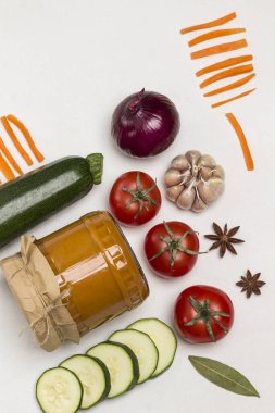 Cam kavanoza yayılmış mayalanmış kabak. Çiğ sebze ve baharat: havuç sarımsak, soğan domates, yıldız anason, acı biber. Sağlıklı kış besinleri. Fermantasyon Ürünleri. Beyaz arka plan. Düz yatıyordu