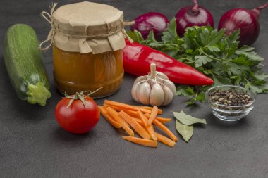 Cam kavanoza yayılmış kabak konservesi. Çiğ sebze ve baharat: havuç sarımsak, soğan domates, yıldız anason, acı biber, maydanoz. Sağlıklı kış besinleri. Fermantasyon Ürünleri. Siyah arkaplan