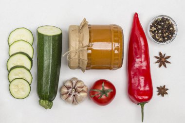 Cam kavanoza yayılmış mayalanmış kabak. Çiğ sebze ve baharat: havuç sarımsak, soğan domates, yıldız anason, acı biber. Sağlıklı kış besinleri. Fermantasyon Ürünleri. Beyaz arka plan. Düz yatıyordu