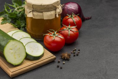 Cam kavanoza yayılmış kabak konservesi. Çiğ sebze ve baharat: havuç sarımsak, soğan domates, biber. Sağlıklı kış besinleri. Fermantasyon Ürünleri. Siyah arka plan. Uzayı kopyala Kapat.