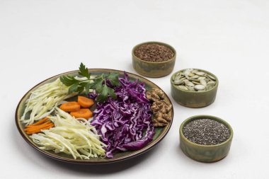 Tabakta dilimlenmiş beyaz ve kırmızı lahana. Keten tohumu, balkabağı tohumu, kutularda siyah chia. Dengeli beslenme. Beyaz arka plan. Boşluğu kopyala