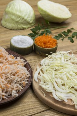 Çiğ lahana ve tuzlanmış lahana. Havuç ve iki yarım lahana. Fermantasyon Ürünleri. Sağlıklı kış besinleri. Kapat.