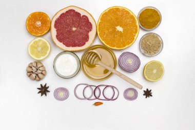 Bağışıklık sistemi için sağlıklı ürünler. Turunçgil, zencefil, bal, sarımsak, soğan. Evde tıbbi beslenme. Beyaz arka plan. Düz yatıyordu