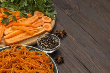 Kesme tahtasında taze doğranmış havuç. Tabakta mayalanmış havuç. Doğal soğuk algınlığı ilacı. Yakın plan. Koyu tahta arkaplan