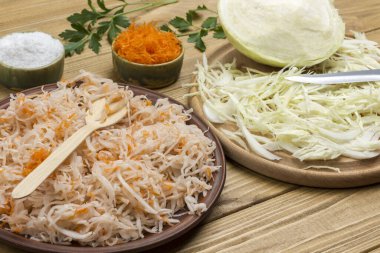 Dilimlenmiş çiğ lahana, tabakta lahana turşusu, yarım lahana kafası. Ev yapımı Fermantasyon Ürünleri. Kapat.